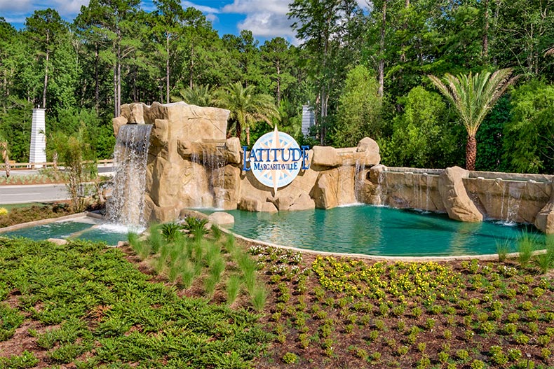 Greenery and a water feature surrounding the community sign for Latitude Margaritaville Hilton Head in Hardeeville, South Carolina