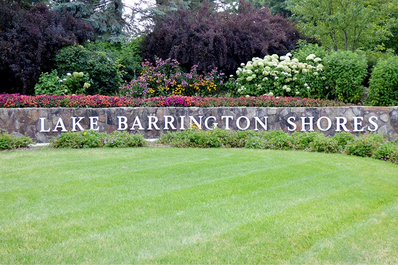 Lush greenery surrounding the community sign for Lake Barrington Shores in Barrington, Illinois