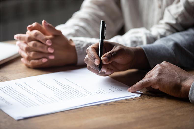 Close up on hands signing a loan agreement with a mortgage lender