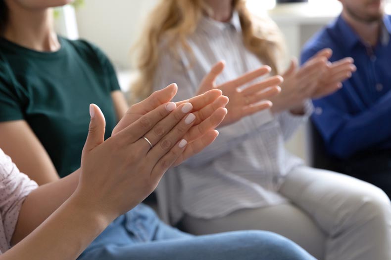 A group of 55+ active adults clapping while doing a club activity in their 55+ community