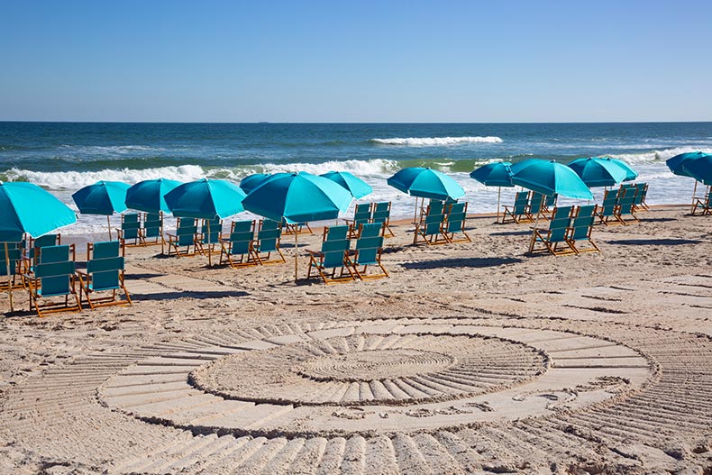 Lounge chairs and beach umbrellas on the sand at the private beach club at Latitude Margaritaville in Daytona Beach, Florida