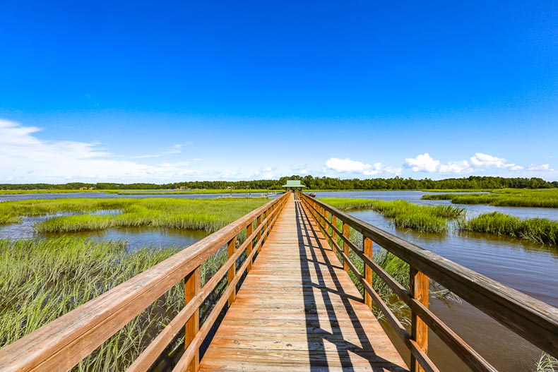 A wooden boardwalk over Riverbend Marsh at Sun City Hilton Head in Bluffton, South Carolina