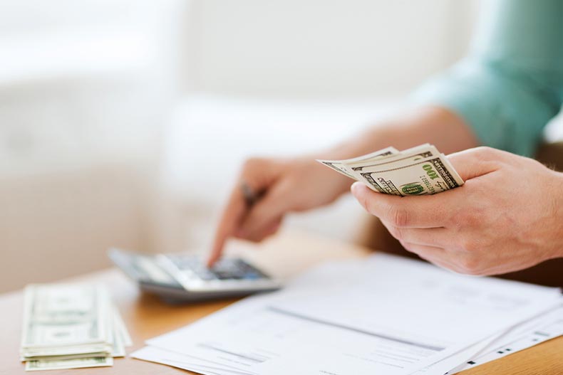 Close up of hands counting money and calculating the payments for a manufactured home