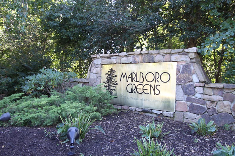 Greenery surrounding the community sign for Marlboro Greens in Englishtown, New Jersey