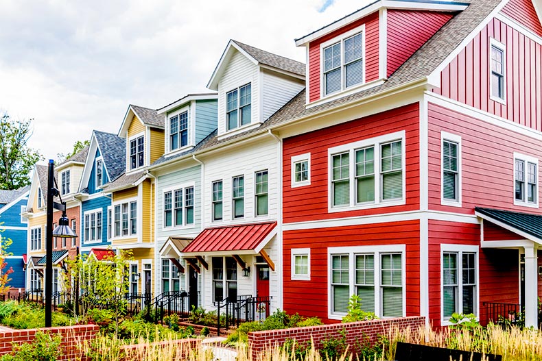 Row of colorful, residential townhouses with brick patio gardens in Maryland