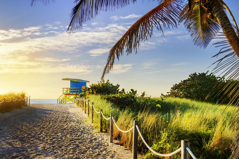 View down a sandy path to a colorful lifeguard tower at South Beach in Miami Beach, Florida