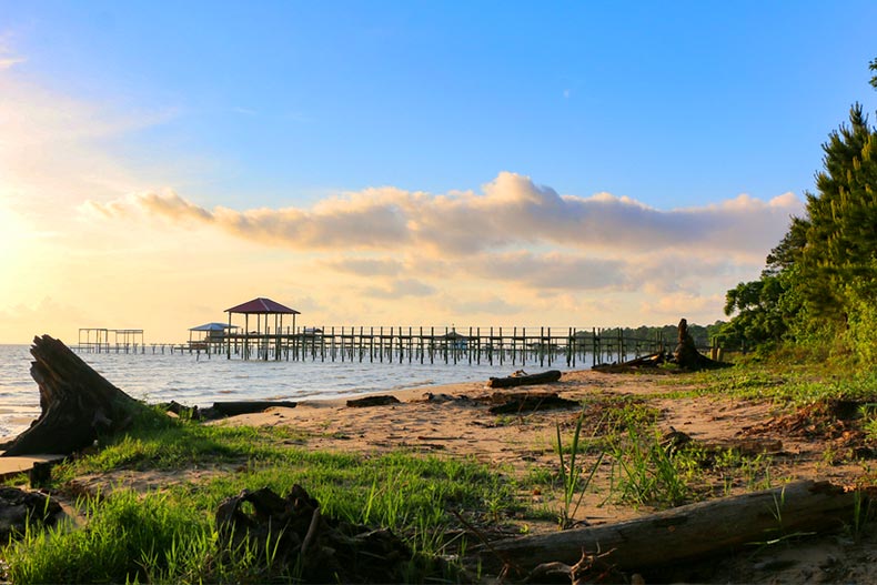 The shoreline along Mobile Bay in Alabama during late afternoon with a pier in the background