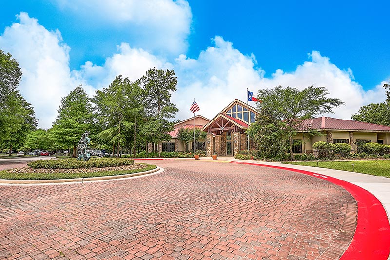 View of the clubhouse at Windsor Lakes in The Woodlands, TX overlooking the circular drive.