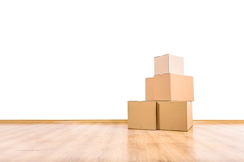 A stack of moving boxes on a wooden floor