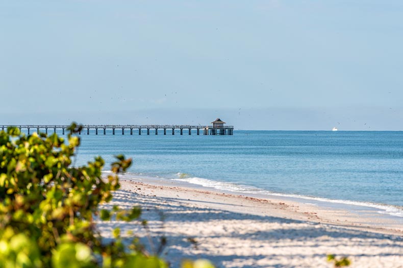 A pier and blue ocean waves in Naples, Florida