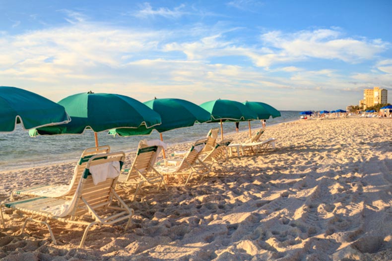 Umbrellas along Vanderbilt Beach in Naples, Florida at sunset