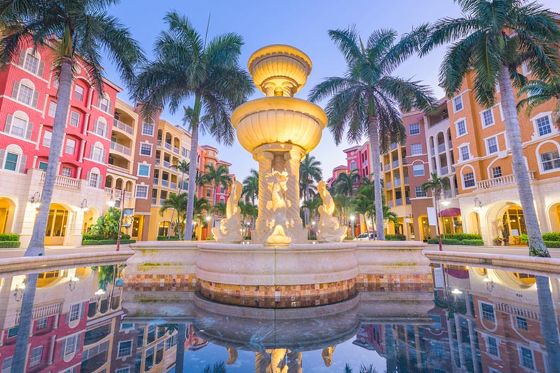 Palm trees surrounding the fountain in the city plaza of Naples, Florida at twilight