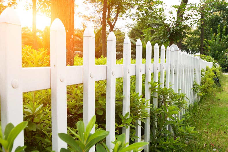 Sunlight on a white, county-style wooden fence in an equestrian retirement community