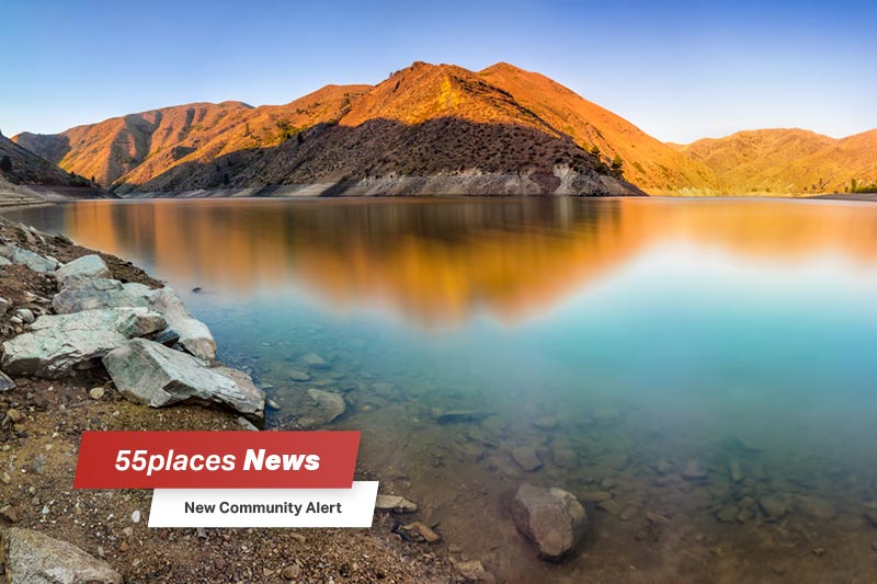 "New Community Alert" banner over a lake surrounded by mountains in Lucky Peak State Park outside Boise, Idaho