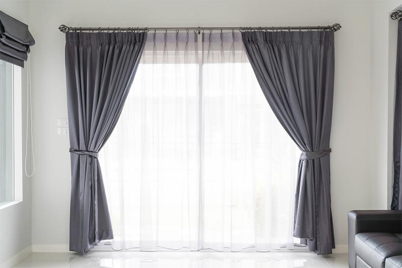 Gray curtains framing a large window in a living room