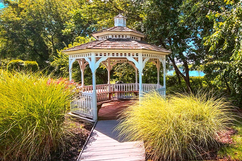 A white gazebo surrounded by bushes and trees at Traditions at Newton's Point in Delanco, New Jersey