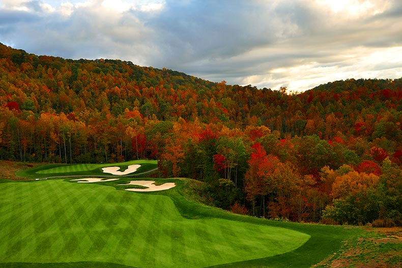 Aerial view of a golf course surrounded by autumn trees in the North Carolina mountains