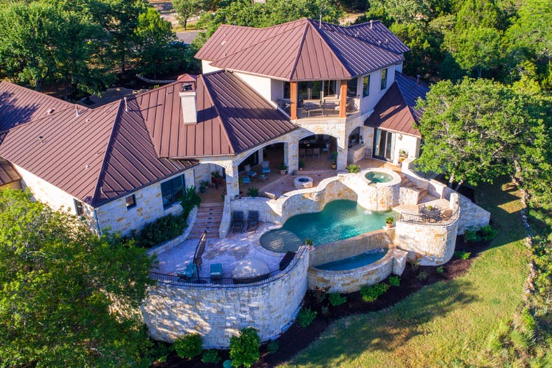 Aerial view of a massive mansion with an outdoor pool