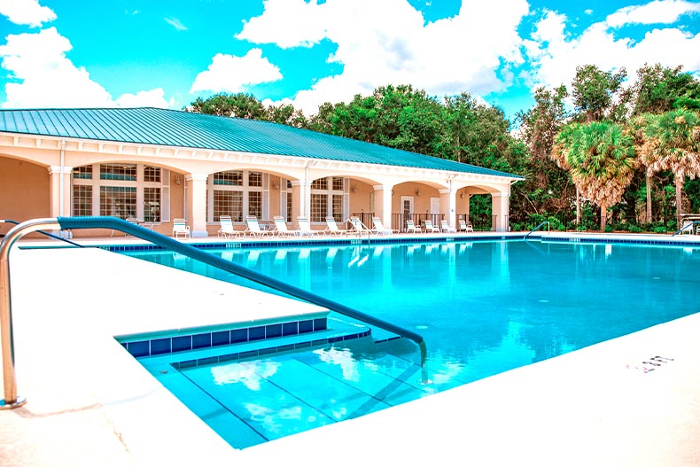 Exterior photo of a clubhouse in Oak Run with a resort-style pool in the foreground, located in Ocala, Florida