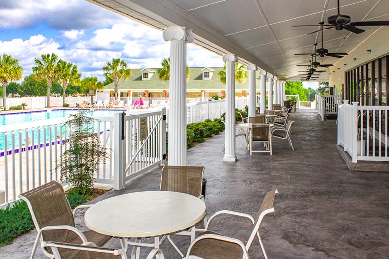 Tables and chairs on the outdoor patio beside the pool at On Top of the World in Ocala, Florida