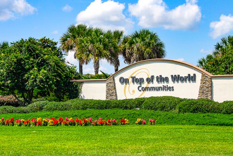 Greenery surrounding the community sign for On Top of the World in Ocala, Florida