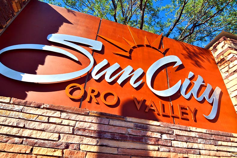 Worms eye view of the orange Sun City Oro Valley welcome sign, located in Oro Valley, Arizona