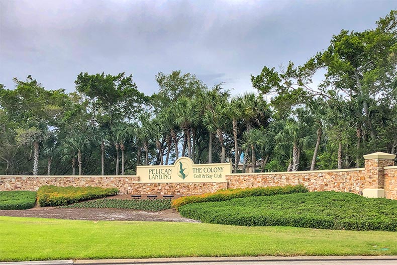 Trees surrounding the community sign for Pelican Landing in Bonita Springs, Florida
