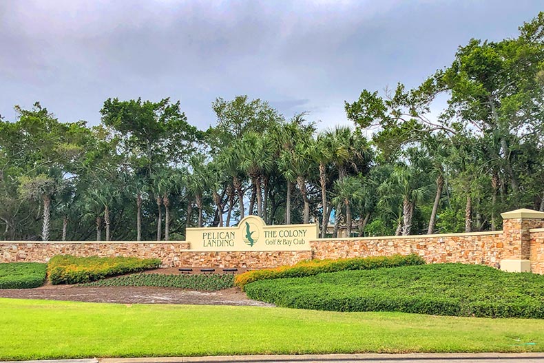 Palm trees and greenery surrounding the community sign for Pelican Landing in Bonita Springs, Florida