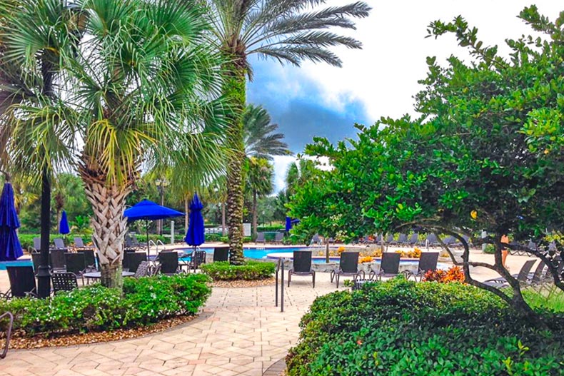 Lounge chairs on the patio beside the outdoor pool at Pelican Preserve in Fort Myers, Florida