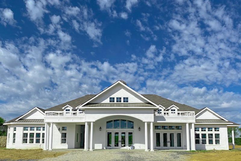 View of the clubhouse at Pelican Preserve on a party cloudy day.