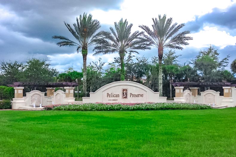 Palm trees and greenery surrounding the community sign for Pelican Preserve in Fort Myers, Florida