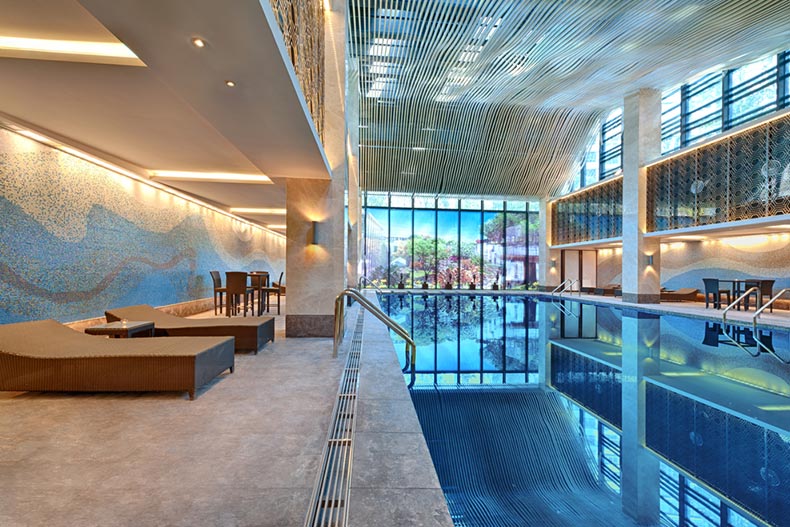 A luxury indoor swimming pool edged with lounge chairs