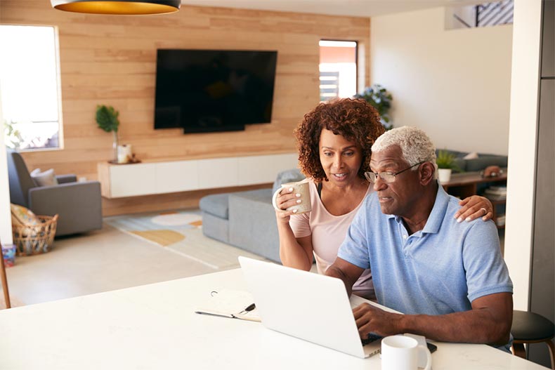 An active adult couple looking at new construction homes for sale online