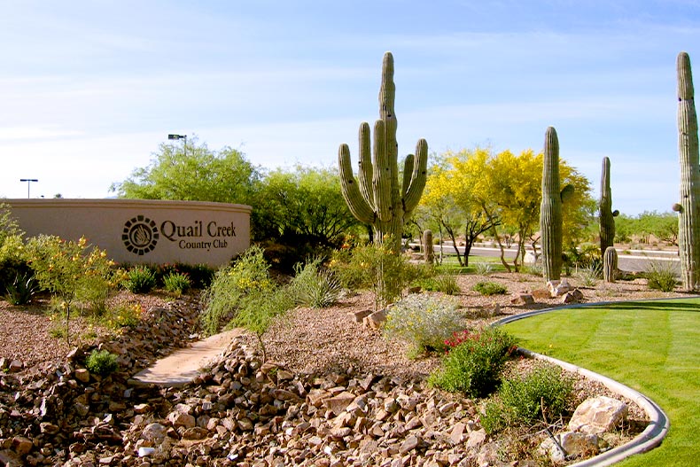 The welcome sign at Quail Creek Country Club in Green Valley, Arizona with some cacti and other plans surrounding