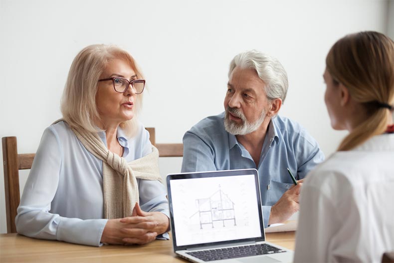 An active adult couple consulting with a salesperson about purchasing a new construction home