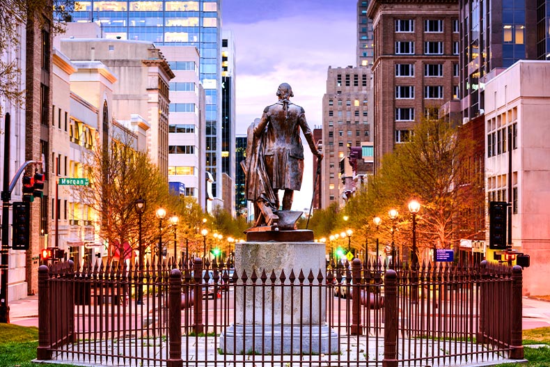 Photo of downtown Raleigh viewed behind a statue on the capital grounds