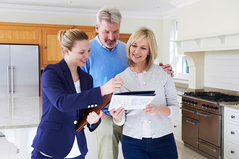 A Realtor showing a mature couple around a new home