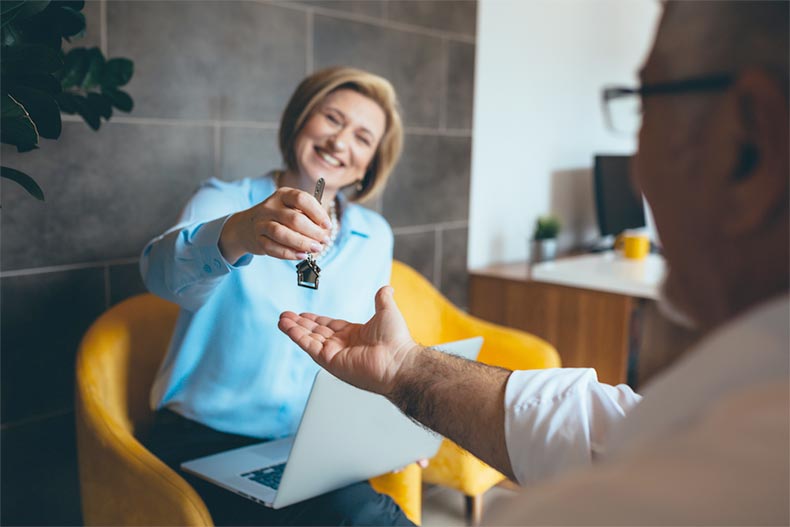 A real estate agent giving house keys to a new homeowner