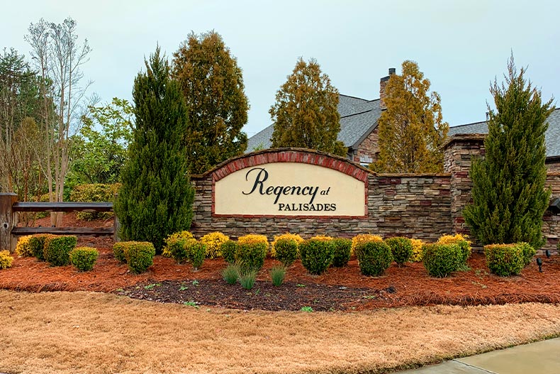 The community sign for Regency at Palisades surrounded by a small shrub garden in Charlotte, North Carolina