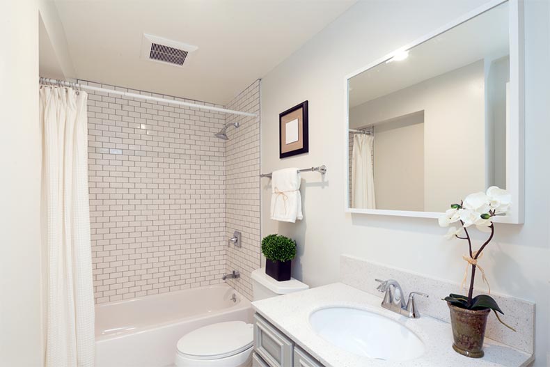 A remodeled bathroom with fresh white furnishings