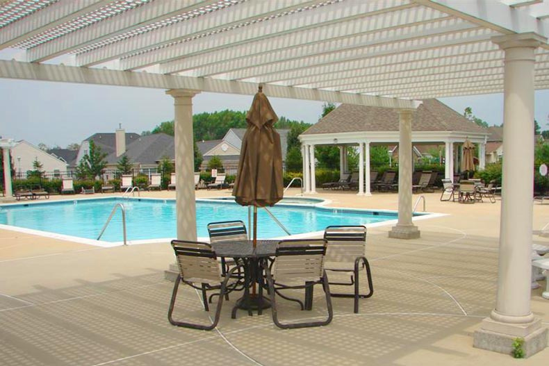 Patio tables and chairs around the outdoor pool at Renaissance at Cranbury Crossing in Monroe, New Jersey