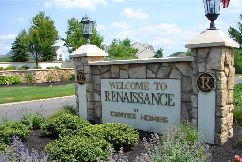 Greenery and flowers surrounding the community sign for Renaissance at Monroe in New Jersey