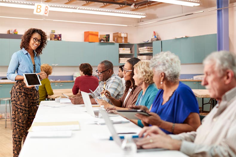 A young woman teaching a technology class in the community center of an active adult community