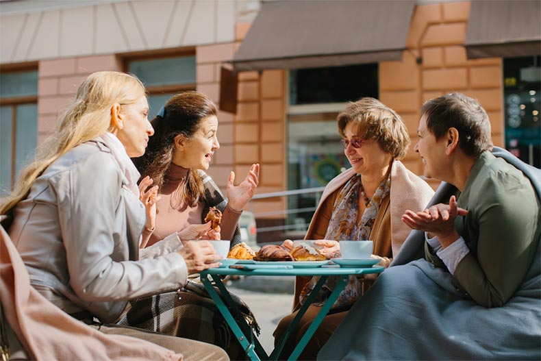 A group of older female friends socializing at a cafe