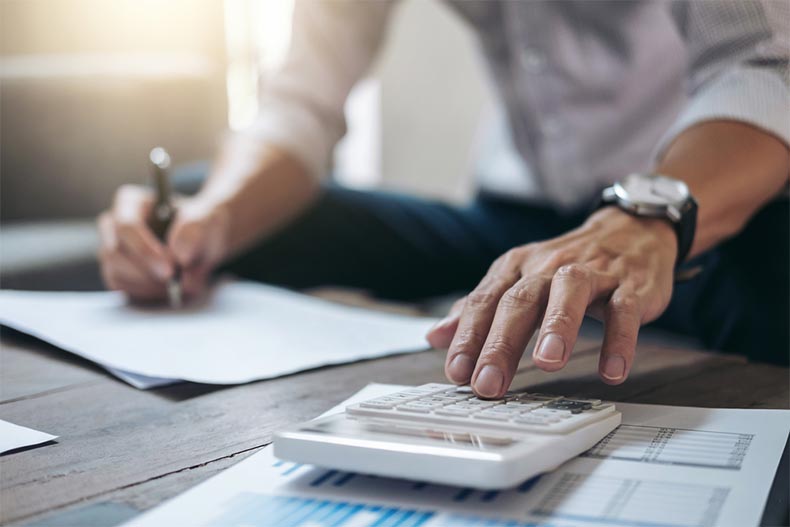 Closeup on hands using a calculator to manage retirement finances