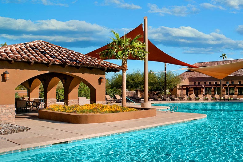 View of a covered patio and resort-style pool in the Robson Ranch community of Eloy, Arizona