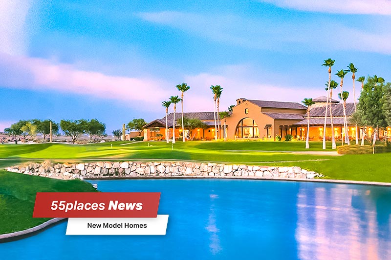 "New Model Homes" banner over palm trees and a pond outside a community building at Robson Ranch in Eloy, Arizona