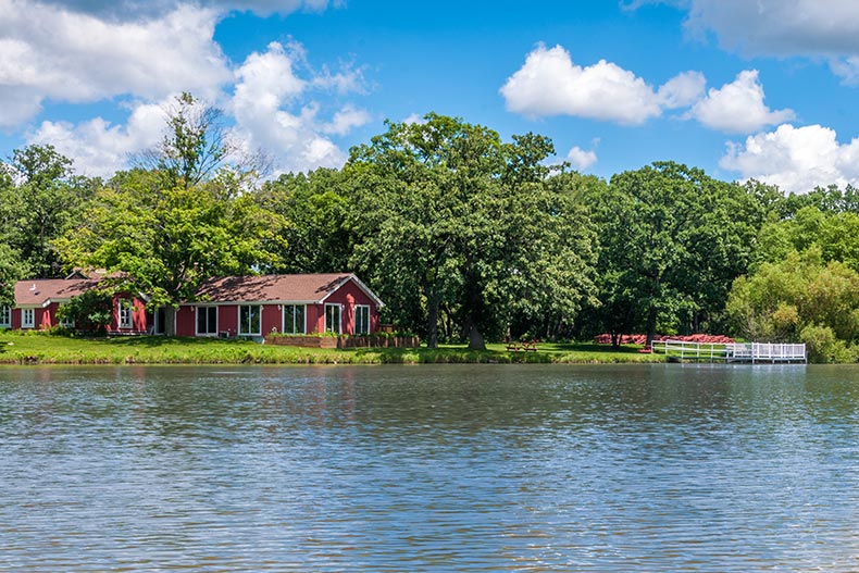 Buildings and trees beside a lake at Saddlebrook Farms in Grayslake, Illinois