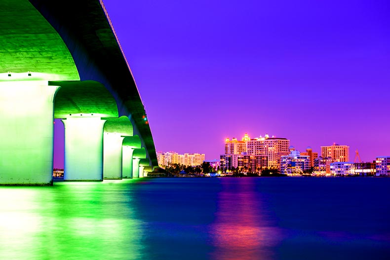 A green underlit bridge leading to downtown Sarasota, Florida