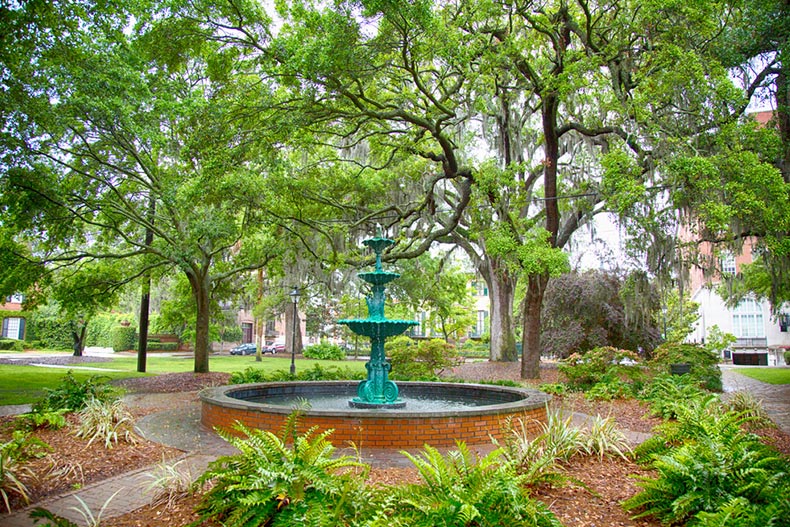 A fountain surrounded by greenery in a park on a stormy day in Savannah, Georgia